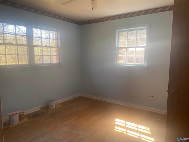 empty room featuring a ceiling fan, baseboards, and wood finished floors