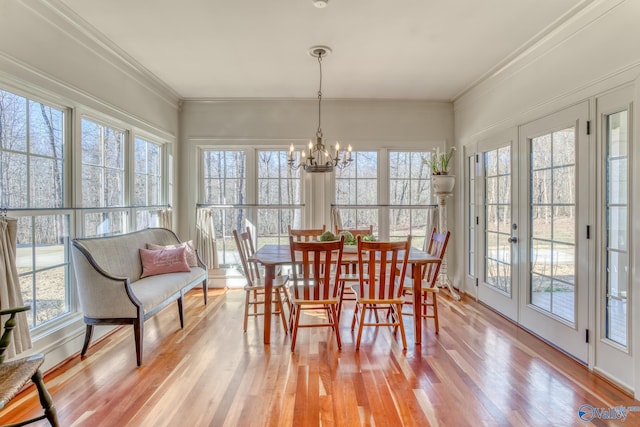 sunroom featuring a wealth of natural light and a notable chandelier