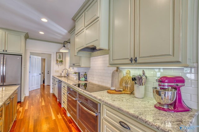 kitchen featuring decorative light fixtures, stainless steel appliances, light hardwood / wood-style floors, backsplash, and custom range hood