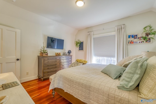 bedroom with vaulted ceiling and hardwood / wood-style floors