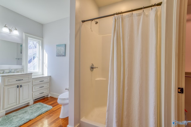 bathroom featuring hardwood / wood-style flooring, toilet, vanity, and a shower with shower curtain