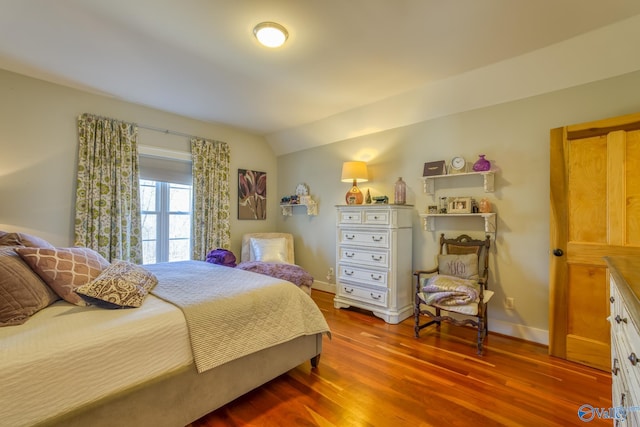 bedroom with lofted ceiling and wood-type flooring