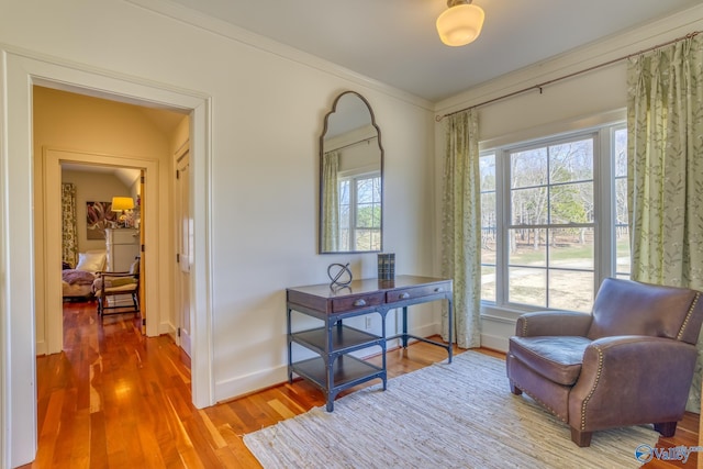 sitting room with wood-type flooring and crown molding