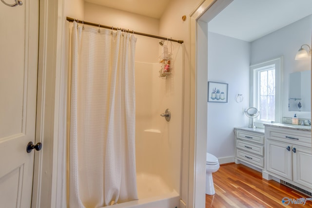 bathroom with hardwood / wood-style flooring, curtained shower, toilet, and vanity