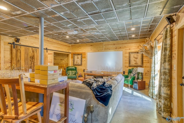 basement featuring a barn door and wood walls