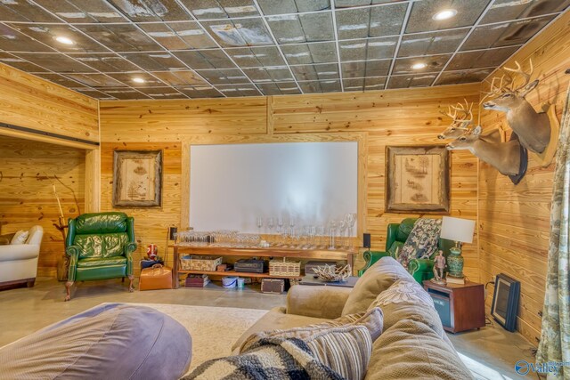 living room with a drop ceiling and wooden walls