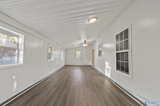 empty room featuring lofted ceiling, ceiling fan, plenty of natural light, and dark hardwood / wood-style floors