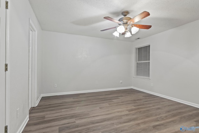 empty room featuring a textured ceiling, dark hardwood / wood-style flooring, and ceiling fan