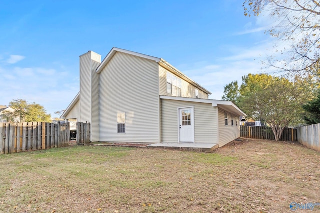 back of house with a yard and a patio area