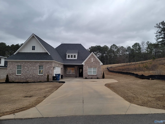 view of front facade with board and batten siding, roof with shingles, concrete driveway, a garage, and brick siding