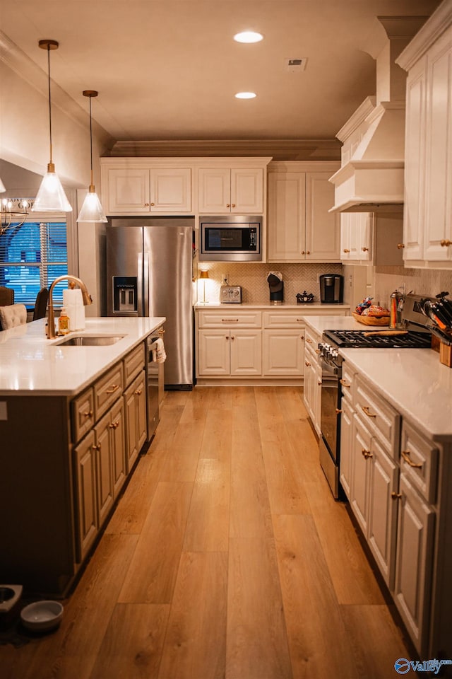 kitchen with white cabinets, stainless steel appliances, custom range hood, and a sink