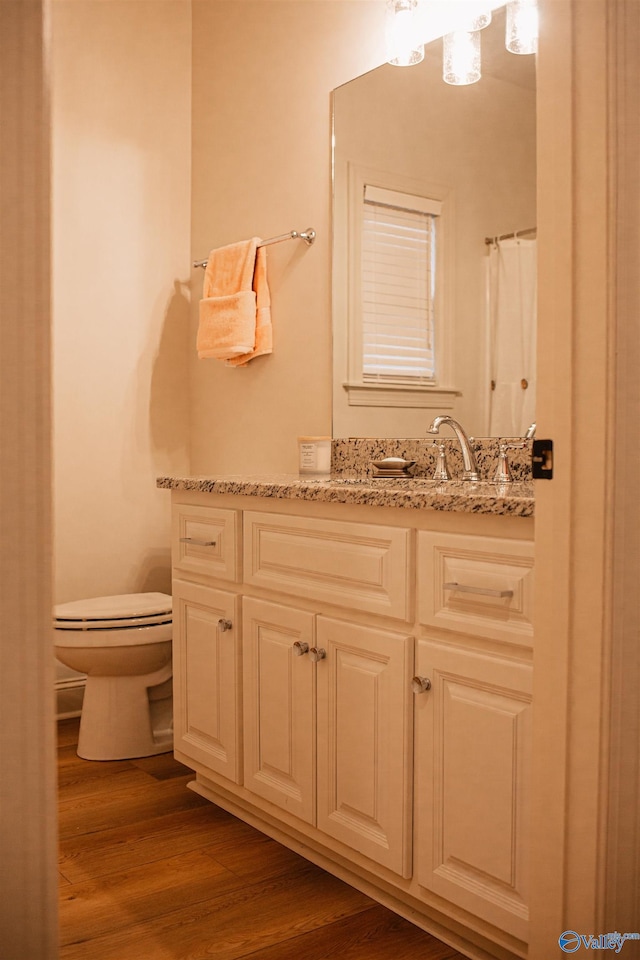 full bath with vanity, toilet, and wood finished floors