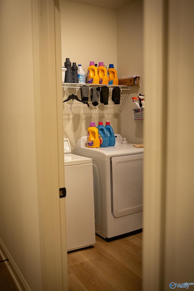 laundry area featuring light wood-type flooring, washing machine and dryer, and laundry area