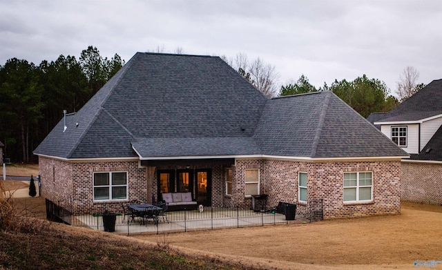 back of property featuring a patio, brick siding, and a shingled roof