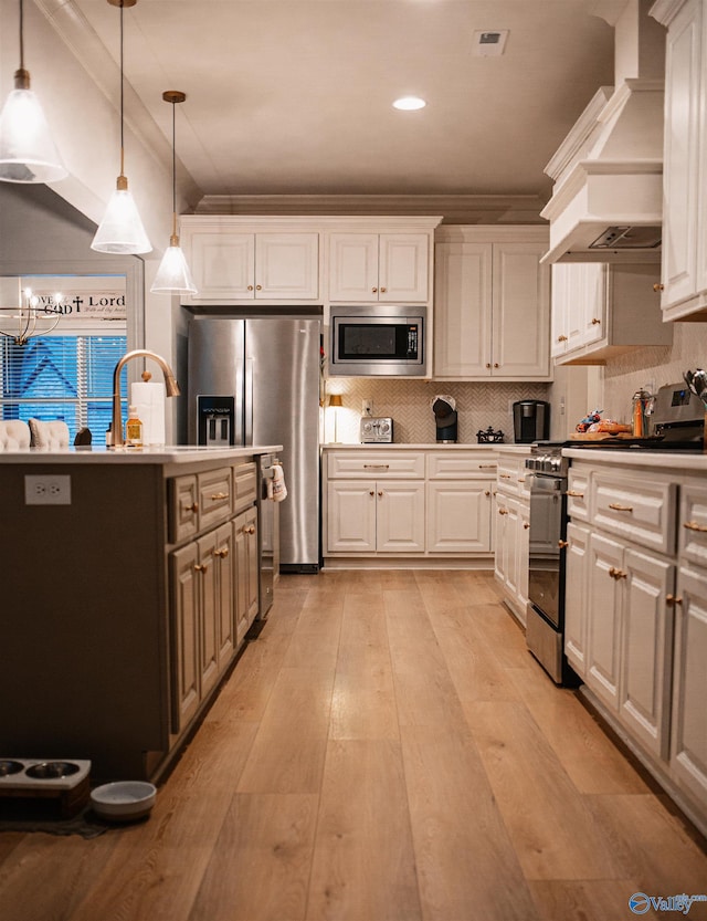 kitchen featuring custom exhaust hood, white cabinets, and appliances with stainless steel finishes