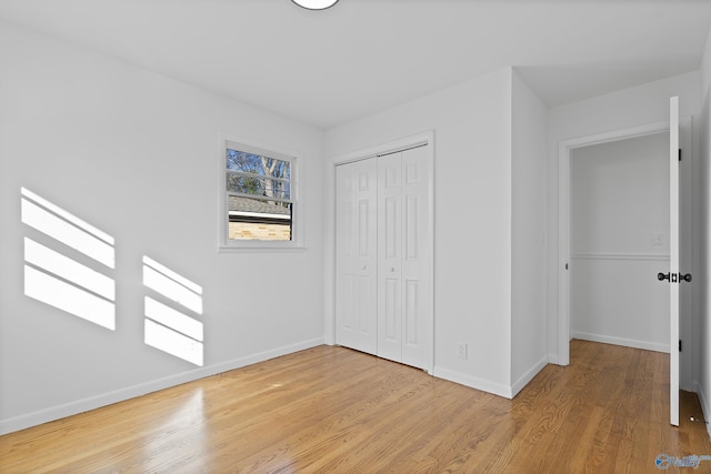 unfurnished bedroom with light hardwood / wood-style floors and a closet