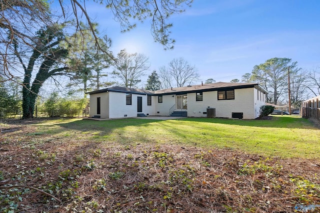 back of property featuring a lawn and central air condition unit