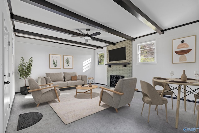 carpeted living room featuring a fireplace, beam ceiling, and ceiling fan