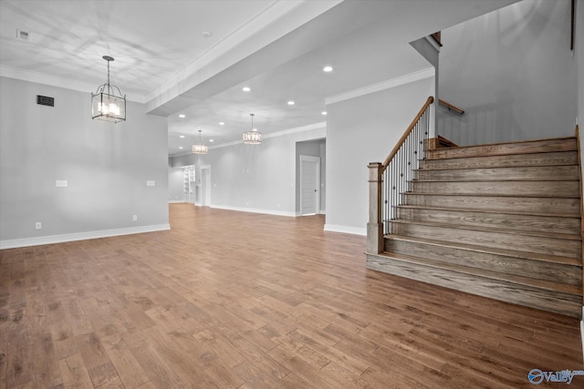 unfurnished living room with light hardwood / wood-style flooring, ornamental molding, and a notable chandelier