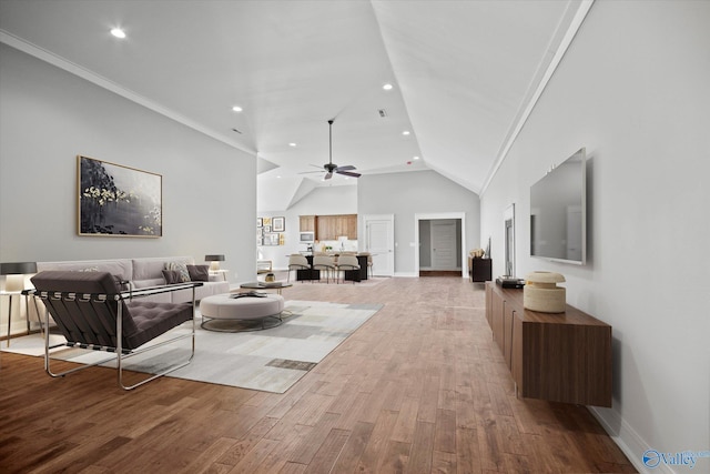 living room featuring hardwood / wood-style floors, vaulted ceiling, ceiling fan, and crown molding