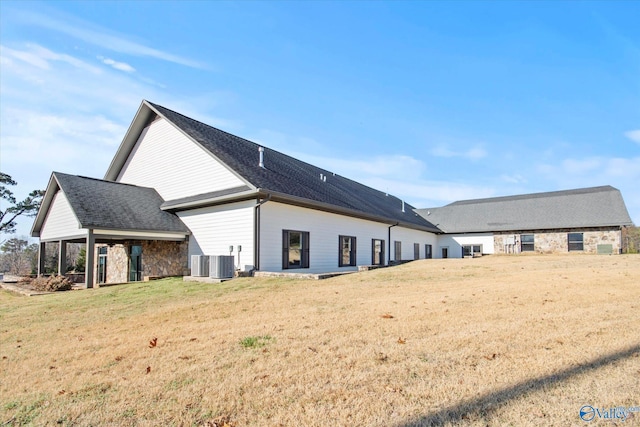 rear view of property featuring a yard and central AC unit