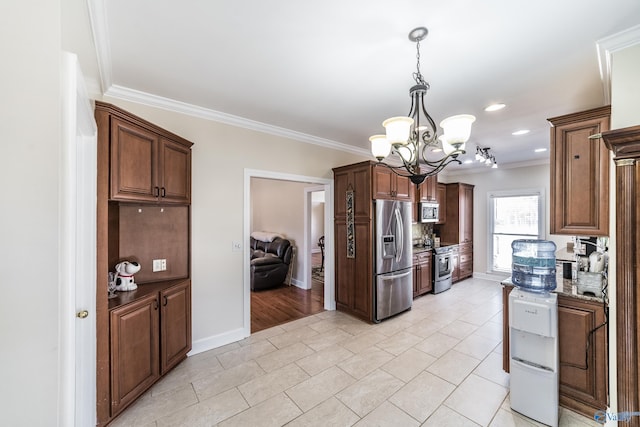 kitchen featuring stainless steel appliances, baseboards, crown molding, light stone countertops, and hanging light fixtures