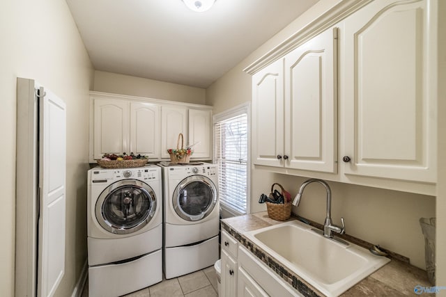 washroom with a sink, cabinet space, separate washer and dryer, and light tile patterned flooring