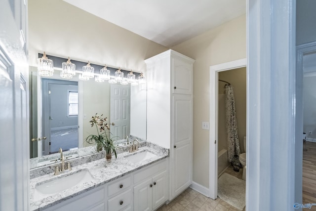 full bath featuring double vanity, toilet, shower / bath combo, and a sink