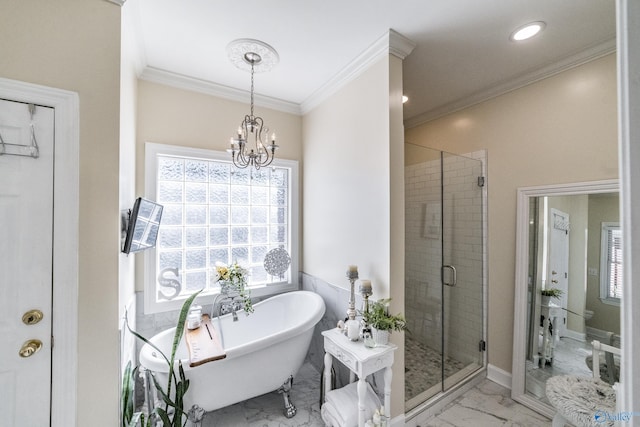 bathroom featuring an inviting chandelier, a soaking tub, ornamental molding, a shower stall, and marble finish floor