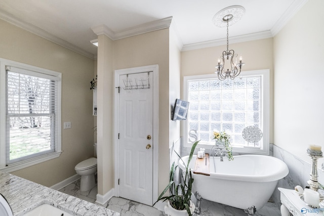 bathroom with a freestanding bath, crown molding, marble finish floor, and a chandelier