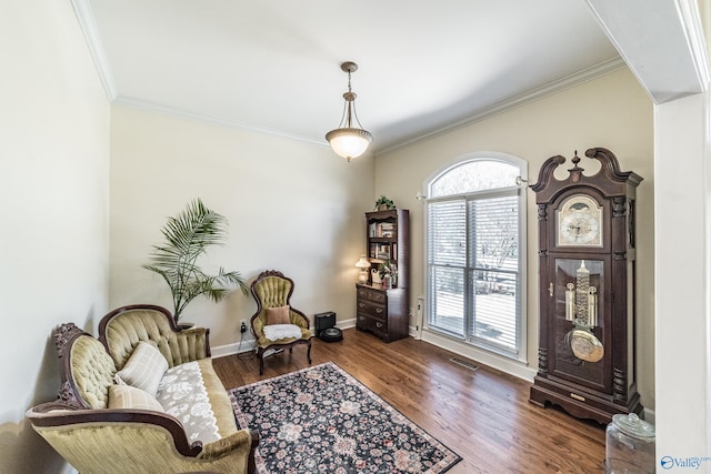 living area featuring visible vents, wood finished floors, baseboards, and ornamental molding