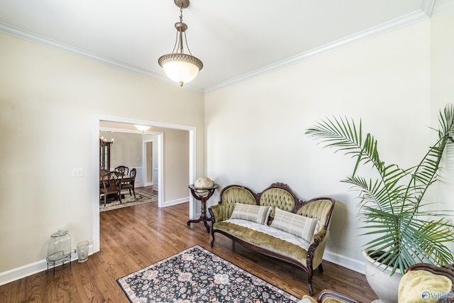 sitting room with crown molding, wood finished floors, and baseboards