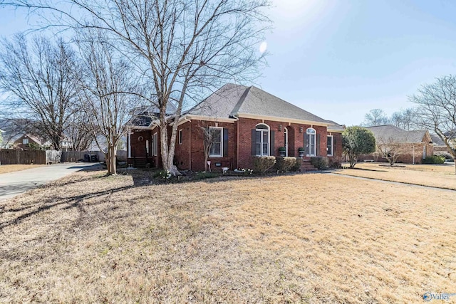 view of front of house featuring fence and brick siding