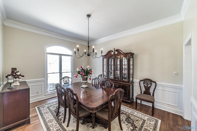 dining room featuring wood finished floors, a chandelier, and wainscoting