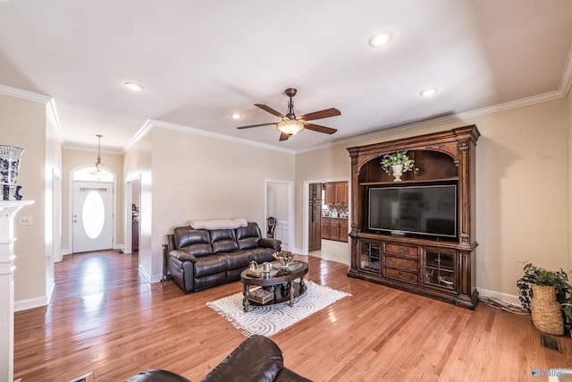 living area with light wood-type flooring, baseboards, and ornamental molding