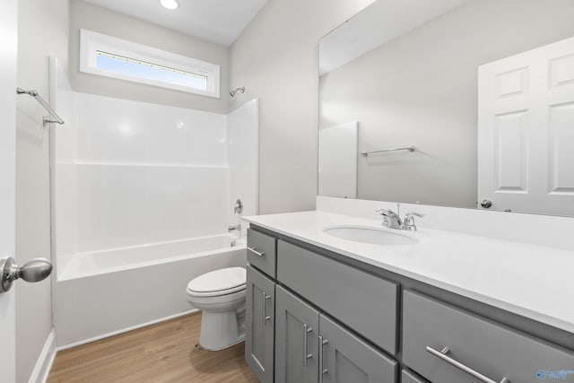 bathroom with toilet, vanity,  shower combination, and wood finished floors