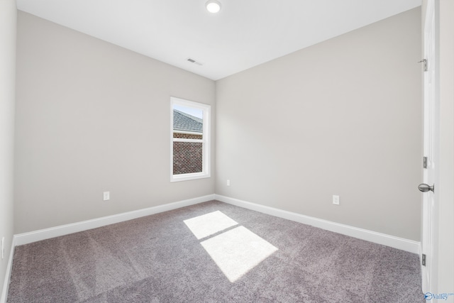 carpeted spare room featuring visible vents and baseboards