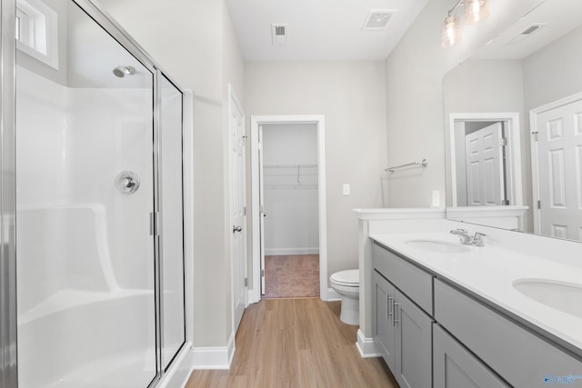 full bath featuring visible vents, a stall shower, wood finished floors, and a sink