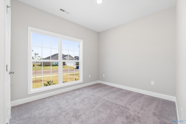 spare room featuring visible vents, baseboards, and carpet floors