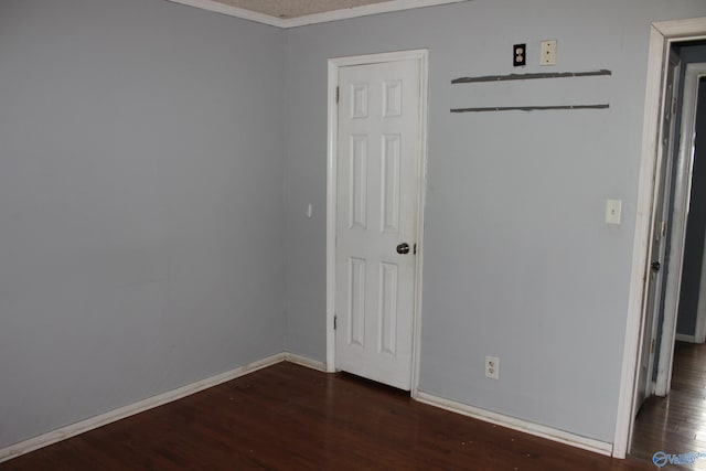 spare room with crown molding and dark hardwood / wood-style flooring