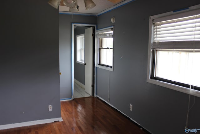 empty room with ceiling fan and hardwood / wood-style flooring