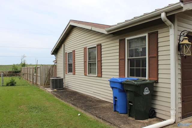 view of home's exterior featuring a lawn and central AC