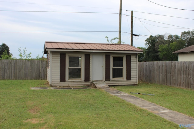 view of front of house with an outdoor structure and a front yard