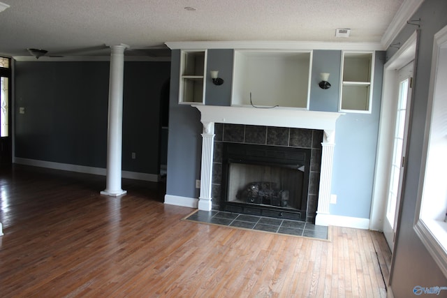 unfurnished living room featuring a textured ceiling, hardwood / wood-style flooring, a fireplace, and crown molding