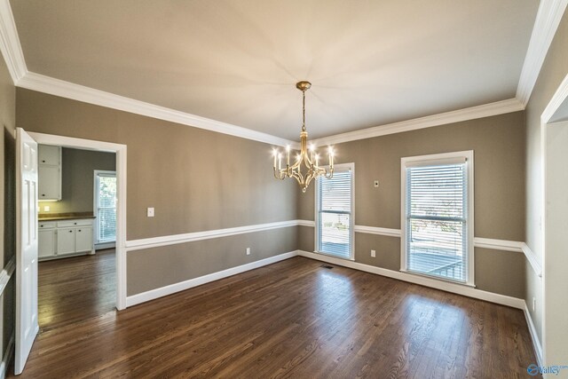 unfurnished room with a chandelier, dark hardwood / wood-style floors, and ornamental molding