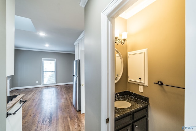 bathroom featuring hardwood / wood-style floors, vanity, and ornamental molding