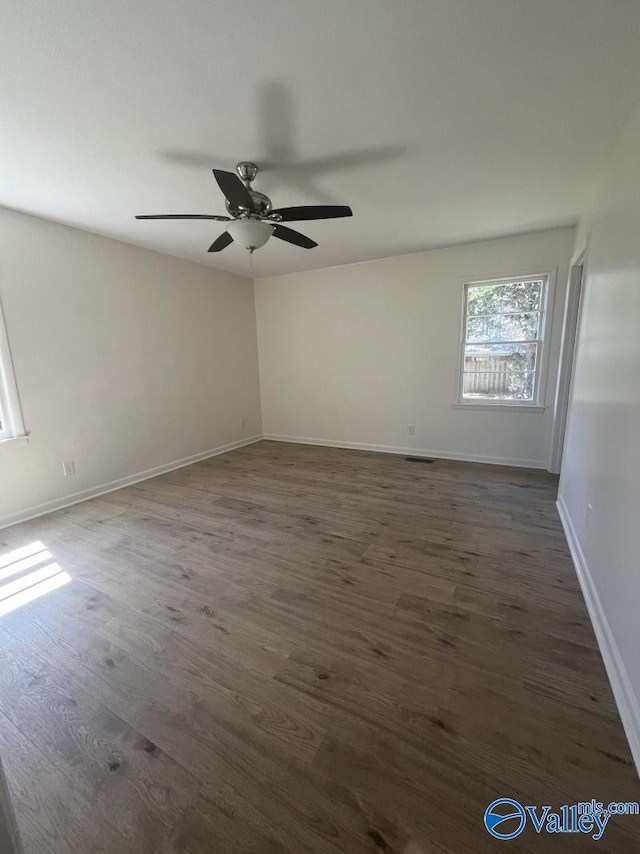 unfurnished room with dark hardwood / wood-style flooring and ceiling fan