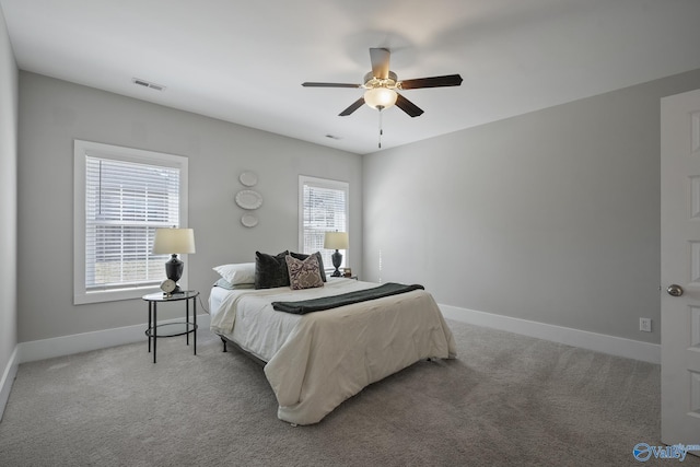 bedroom with baseboards, carpet floors, visible vents, and a ceiling fan