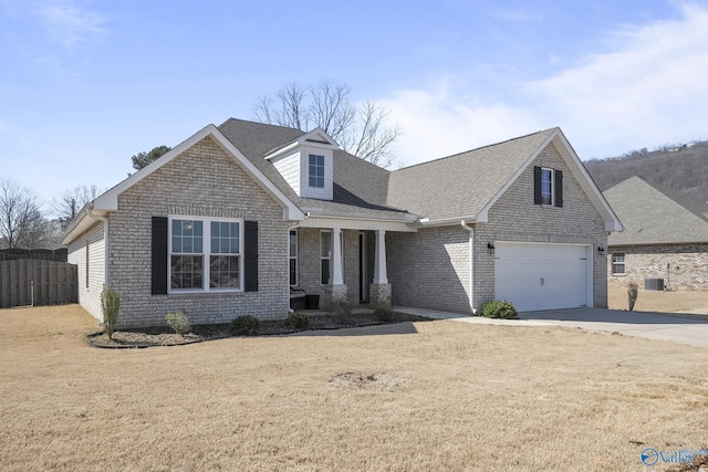 view of front of house featuring driveway, fence, a front yard, a shingled roof, and brick siding