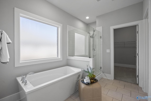 bathroom featuring tile patterned floors, a stall shower, recessed lighting, a soaking tub, and a spacious closet